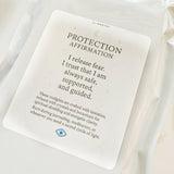 White candle with a 'Protection Affirmation' card on a white background