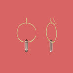 Gold hoop earrings with smoky quartz stones on a pink background