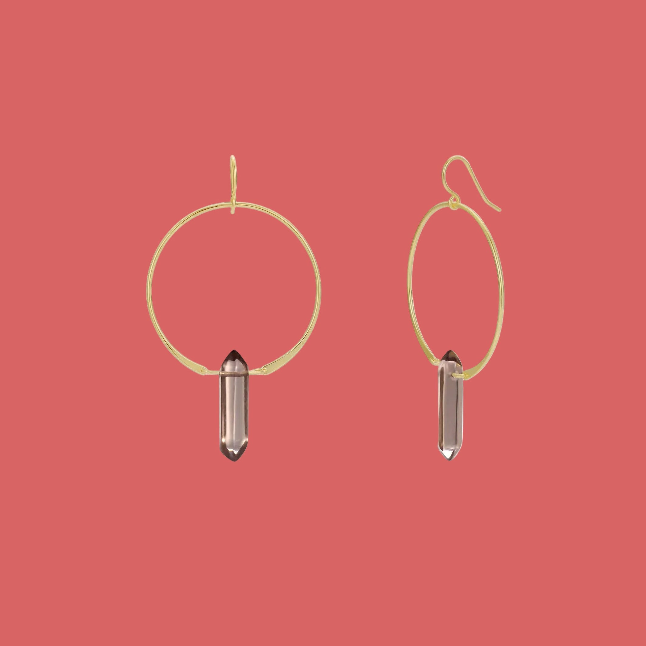 Gold hoop earrings with smoky quartz stones on a pink background