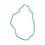 Turquoise beaded necklace on a light gray background