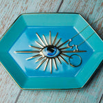 Turquoise jewelry dish with decorative necklace on a wooden surface