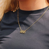 Gold necklace with '888' pendant on a person wearing a black shirt.