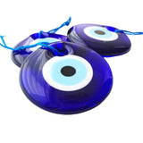 Blue evil eye charms with white centers on a white background