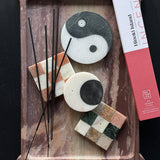 Decorative items including stones with checkered patterns and incense sticks on a wooden tray, with a box labeled 'Hokkaido Island' in the background.