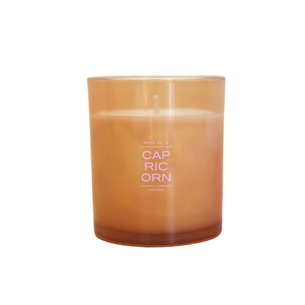 A Capricorn scented candle in a translucent amber glass jar, featuring a white wick and white printed text on the front, set against a white background.