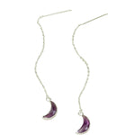 Silver earrings with purple crescent moon charms on a light background