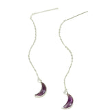 Silver earrings with purple crescent moon charms on a light background