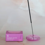 Incense holder with a pink box on a light marble surface
