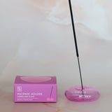 Incense holder with a pink box on a light marble surface