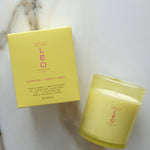Yellow candle and box with 'LEO' branding on a marble surface