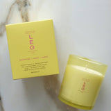 Yellow candle and box with 'LEO' branding on a marble surface