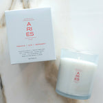 Candle and packaging with 'ARIES' branding on a marble surface