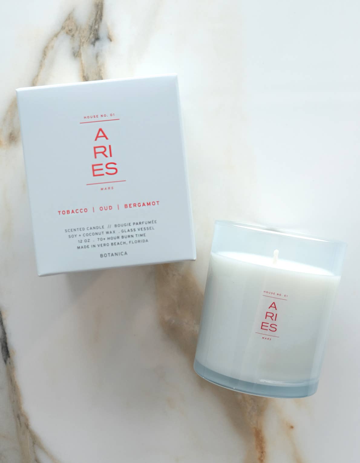 Candle and packaging with 'ARIES' branding on a marble surface