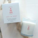 Candle and packaging with 'ARIES' branding on a marble surface
