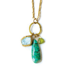Necklace with gold chain, green and blue stone pendants on a white background