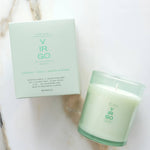 Green candle and packaging on a marble surface