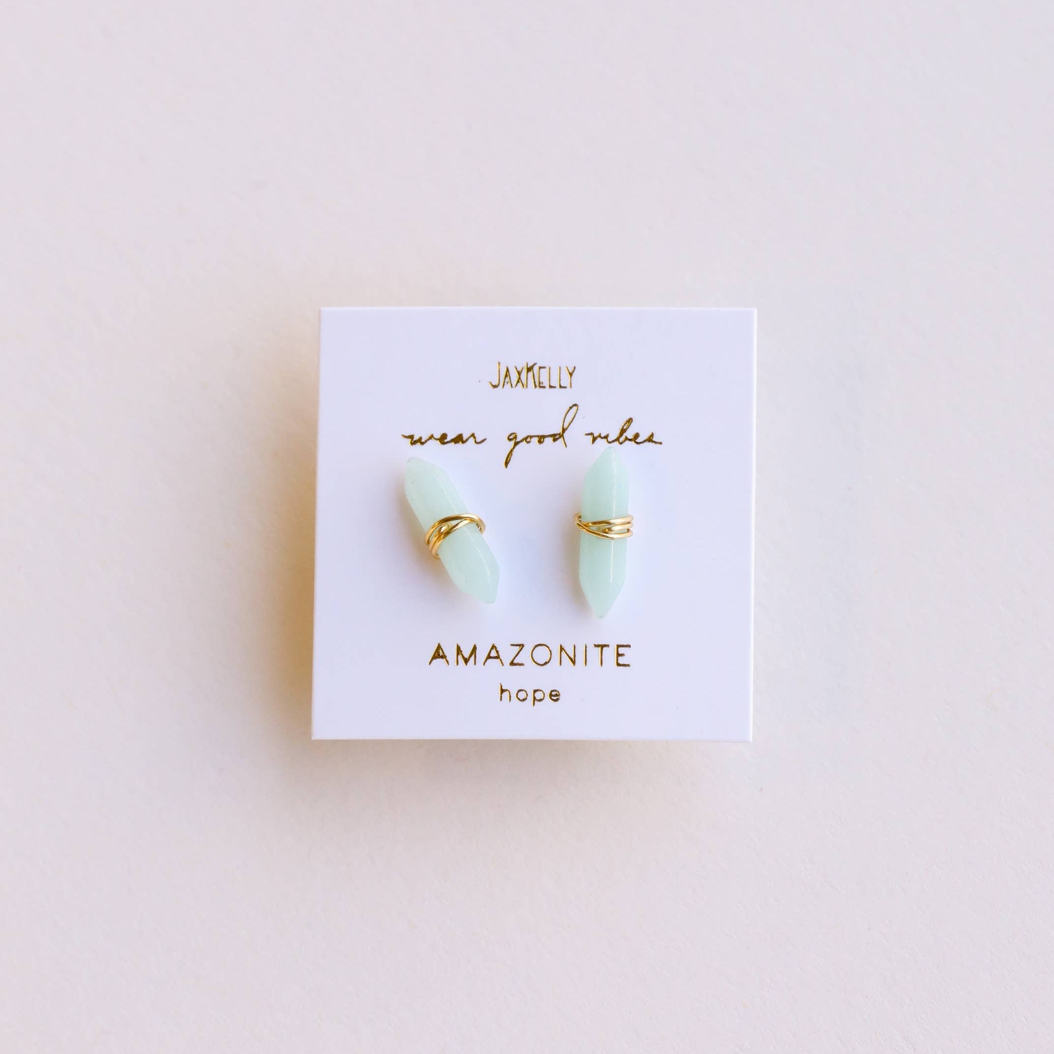 Pair of earrings on a Janelley branded card with 'Amazonite' text on a light background