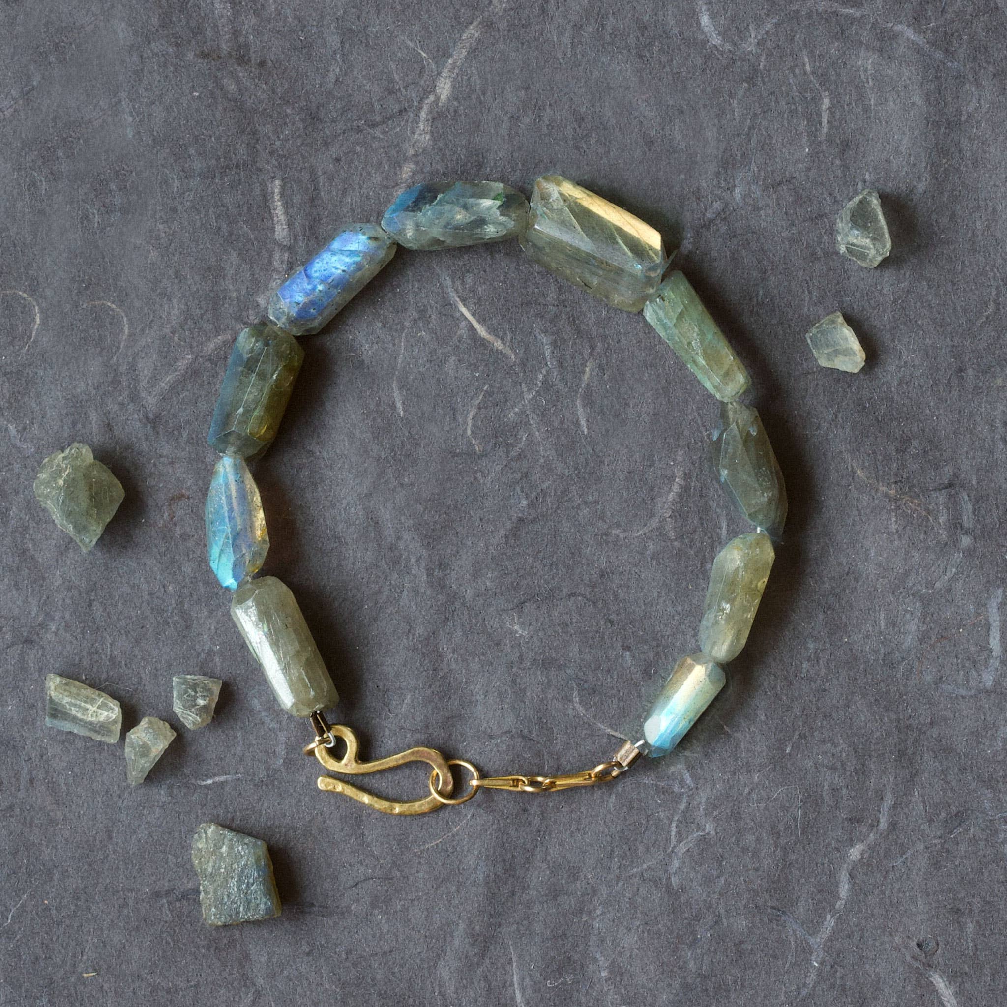 Bracelet with green gemstones on a gray surface