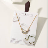 Gold necklace with crescent moon shaped moonstone pendant displayed on a Luna Norte Jewelry card