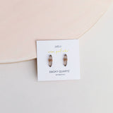 Smoky quartz earrings on a branded card with a pink background