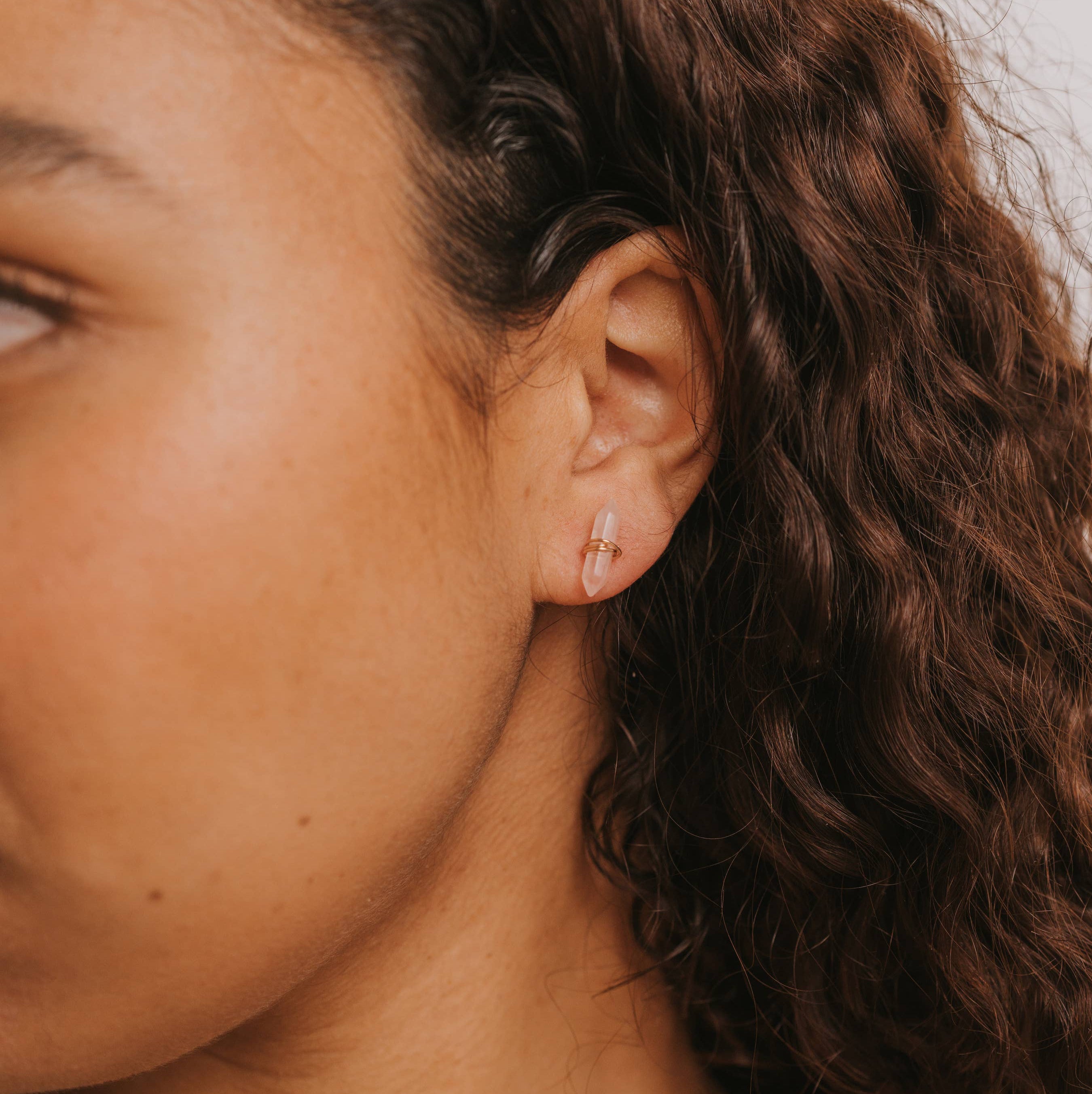 Close-up of a person's ear with an earring, focusing on the jewelry.