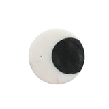 A round white stone or resin cabochon with a pre-drilled hole, featuring a large black half-circle design on one side, photographed on a clean white background.