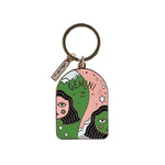 Colorful enamel and brass keychain with GEMINI and two faces on a white background