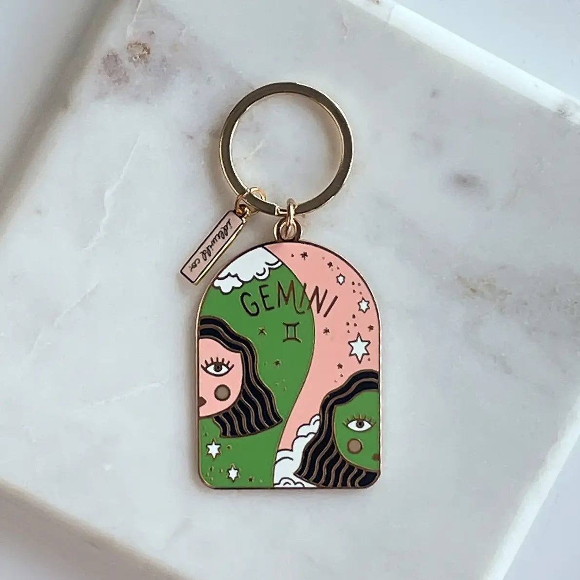 Keychain with Gemini zodiac design on a marble surface