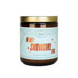 Candle jar with a label reading 'In My Showgirl Era' on a white background