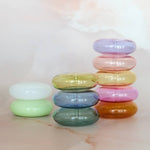 Stack of colorful transparent rings on a marble surface with a soft blurred background