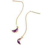 Gold earrings with purple crescent moon charms on a white background