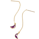 Gold earrings with purple crescent moon charms on a white background