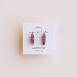Amethyst earrings on a branded card with a light pink background