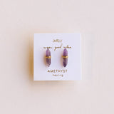 Amethyst earrings on a branded card with a light pink background