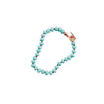 Turquoise beaded bracelet with a gold clasp on a white background