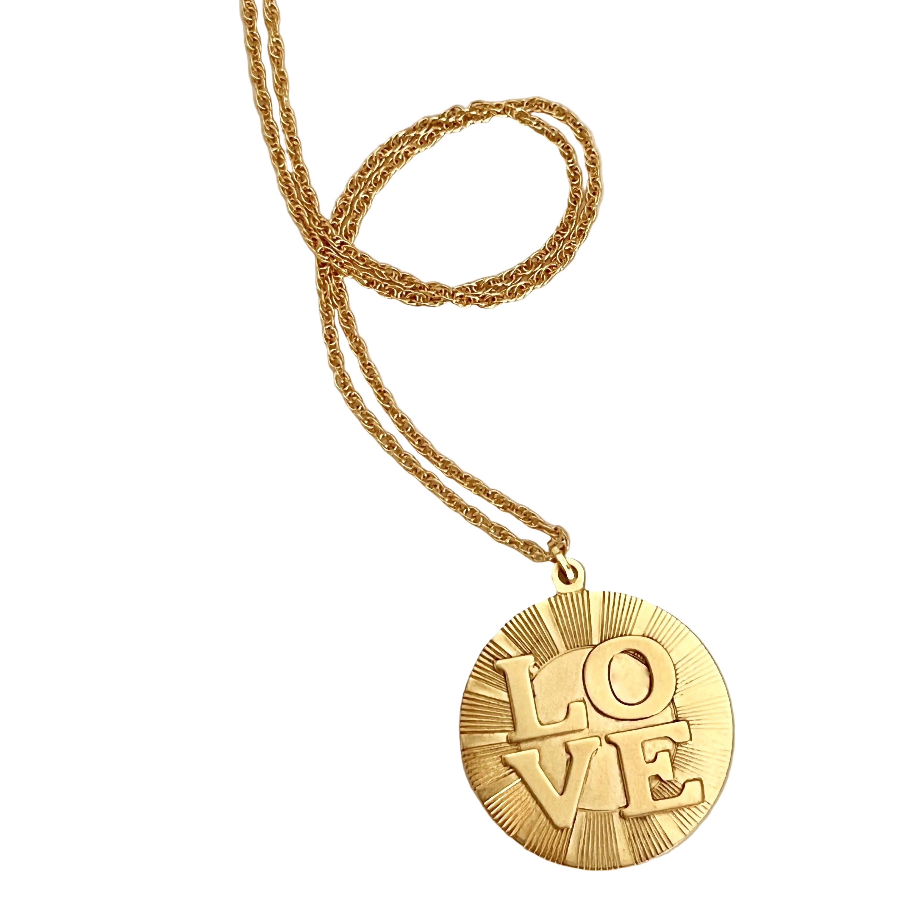 Gold necklace with 'LOVE' pendant on a light gray background