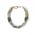 Bracelet with green grey gemstone beads on a white background