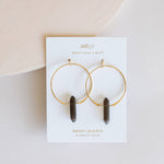 Jamelily earrings with smoky quartz stones on a white card against a beige background