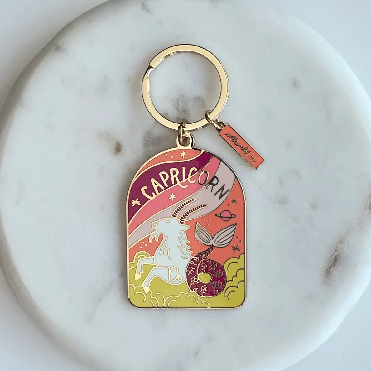 Capricorn zodiac keychain on a marble surface