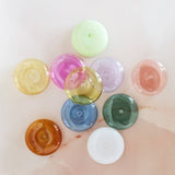 Assorted colored bottle caps on a light background