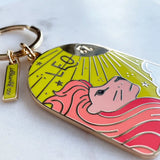 Keychain with astrological design of a lion's face on a yellow background