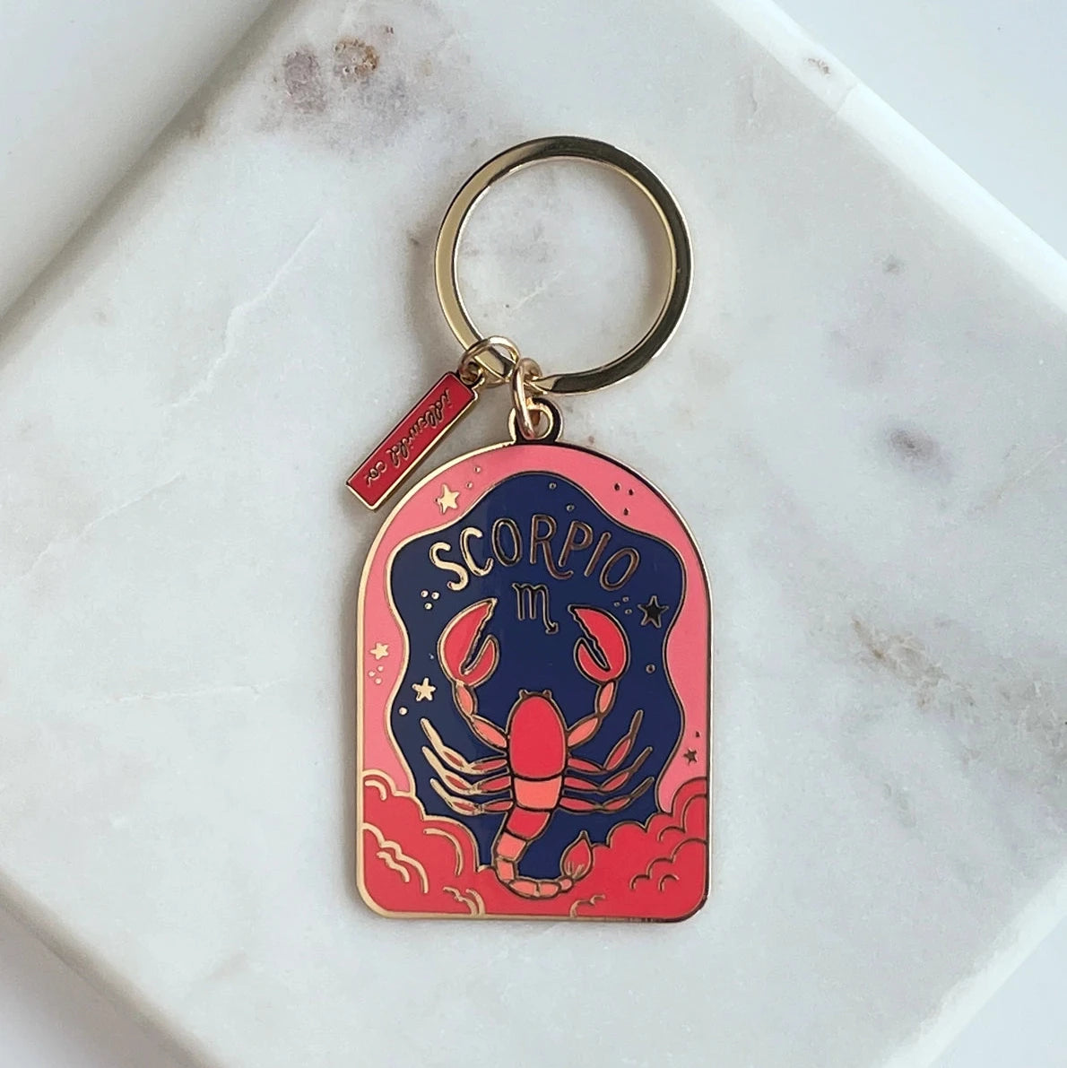 Scorpio zodiac keychain on a marble surface