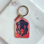 Scorpio zodiac keychain on a marble surface
