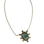 A pendant necklace with a large blue gem surrounded by smaller beige brown gems on a white background