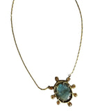 A pendant necklace with a large blue gem surrounded by smaller beige brown gems on a white background