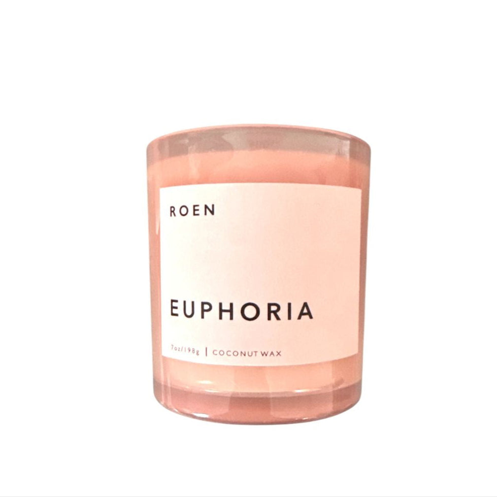 A pink candle labeled 'EUPHORIA' made by ROEN, with a clear glass container and a white label.