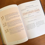 Open book with Expression Number calculations on a wood surface