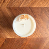 Candle in a white container on a wooden surface
