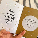 Book open to pages with motivational quotes, held by a hand.
