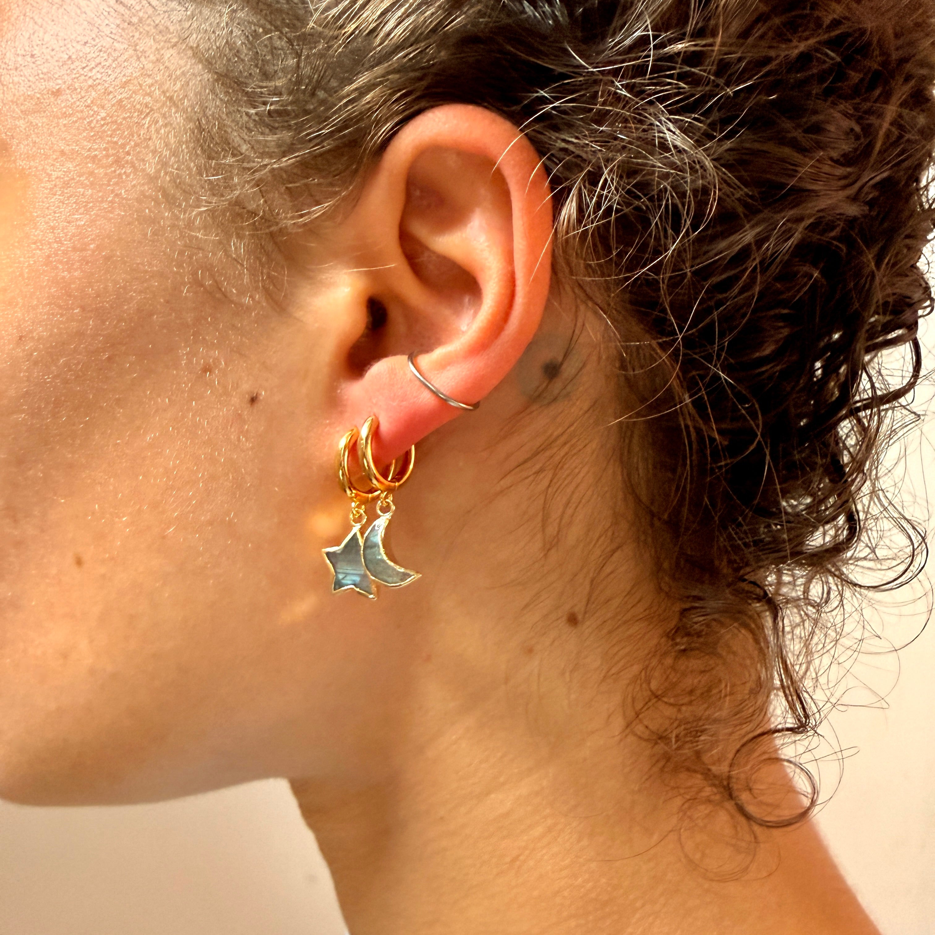 Close up of woman wearing blue star and moon earring